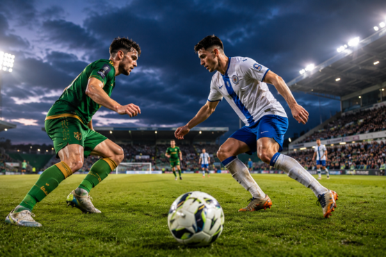 Kerry FC and Finn Harps players competing during a League of Ireland football match in a modern stadium.