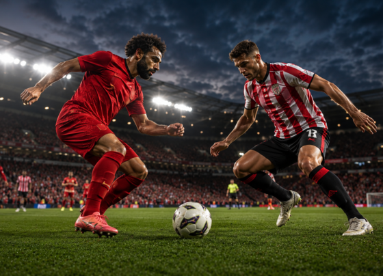 Liverpool and Sunderland players competing during a football match inside a packed stadium under floodlights.